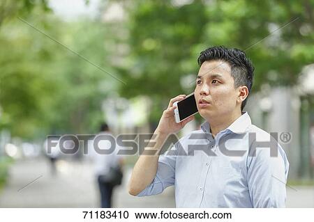 Stock Image - Young Japanese businessman downtown Tokyo. Fotosearch