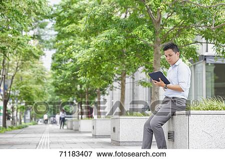 Young Japanese businessman downtown Tokyo View Large Photo Image Stock Photo - Young Japanese businessman downtown Tokyo. Fotosearch