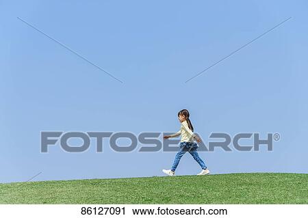 Stock Image - Young Japanese girl and blue sky. Fotosearch