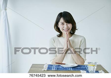 Young Japanese sitting at dining table View Large Photo Image Stock Image - Young Japanese sitting at dining table. Fotosearch