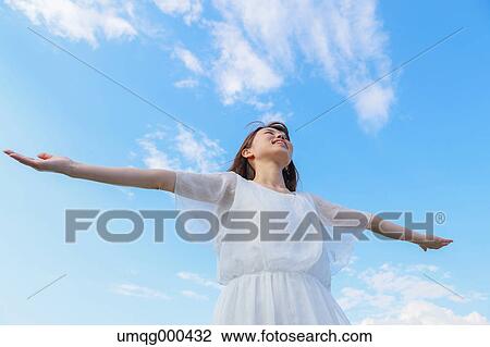 Young Japanese woman against blue sky View Large Photo Image Stock Image - Young Japanese woman against blue sky. Fotosearch