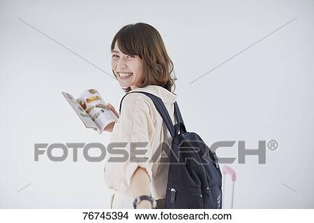 Picture - Young Japanese woman against white wall. Fotosearch