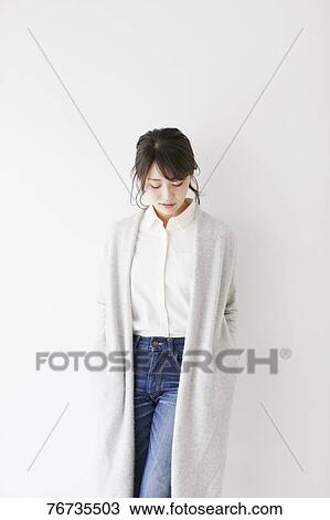 Stock Image - Young Japanese woman against white wall. Fotosearch