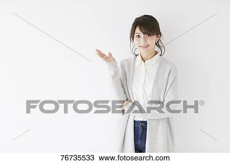 Stock Image - Young Japanese woman against white wall. Fotosearch