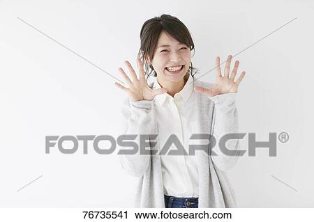 Stock Image - Young Japanese woman against white wall. Fotosearch