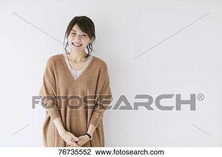 Young Japanese woman against white wall View Large Photo Image Stock Image - Young Japanese woman against white wall. Fotosearch