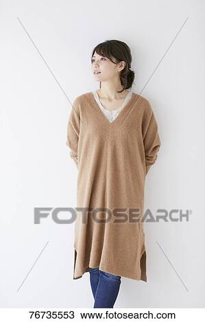 Stock Image - Young Japanese woman against white wall. Fotosearch