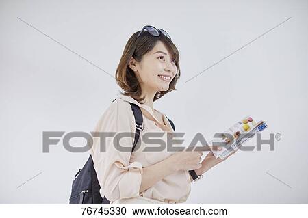 Young Japanese woman against white wall View Large Photo Image Stock Image - Young Japanese woman against white wall. Fotosearch