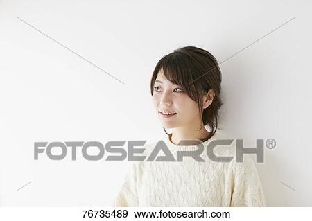 Stock Photo - Young Japanese woman against white wall. Fotosearch