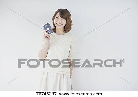 Stock Photo - Young Japanese woman against white wall. Fotosearch