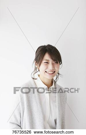 Young Japanese woman against white wall View Large Photo Image Stock Photograph - Young Japanese woman against white wall. Fotosearch