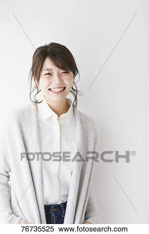 Stock Photography - Young Japanese woman against white wall. Fotosearch