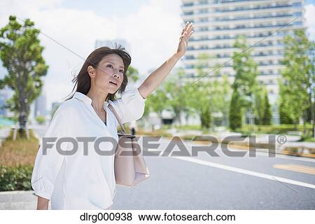 Young Japanese woman calling a taxi downtown Tokyo, Japan View Large Photo Image Stock Photo - Young Japanese woman calling a taxi downtown Tokyo, Japan. Fotosearch