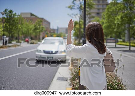 Young Japanese woman calling a taxi downtown Tokyo, Japan View Large Photo Image Stock Photo - Young Japanese woman calling a taxi downtown Tokyo, Japan. Fotosearch