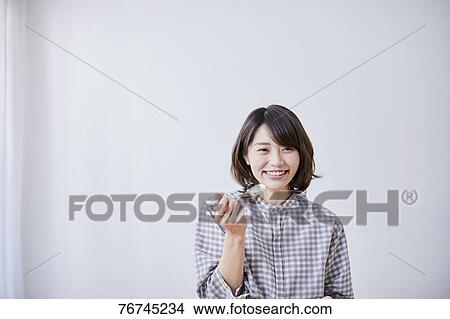Picture - Young Japanese woman eating cake. Fotosearch