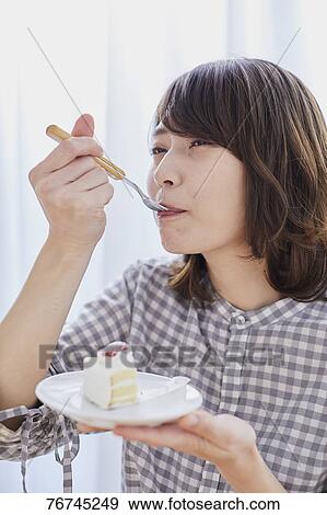 Young Japanese woman eating cake View Large Photo Image Stock Photo - Young Japanese woman eating cake. Fotosearch