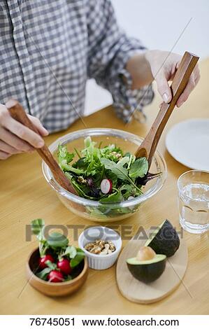 Stock Image - Young Japanese woman eating salad. Fotosearch