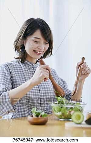 Stock Photo - Young Japanese woman eating salad. Fotosearch