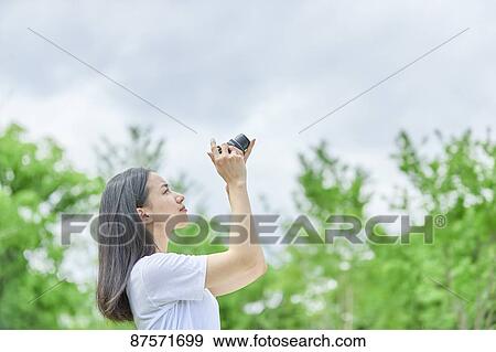 Young Japanese woman in a city park View Large Photo Image Stock Photo - Young Japanese woman in a city park. Fotosearch