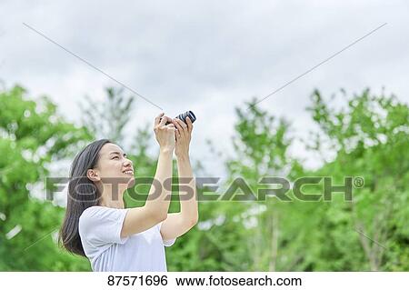 Young Japanese woman in a city park View Large Photo Image Stock Photograph - Young Japanese woman in a city park. Fotosearch