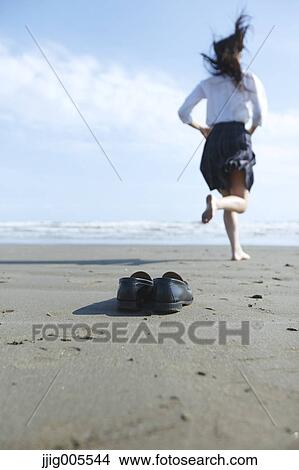 Young Japanese woman in a high school uniform running by the sea, Chiba, Japan View Large Photo Image Picture - Young Japanese woman in a high school uniform running by the sea, Chiba, Japan. Fotosearch