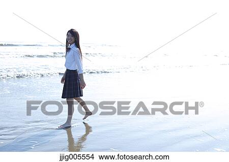 Picture - Young Japanese woman in a high school uniform by the sea, Chiba, Japan. Fotosearch