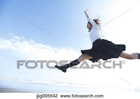 Young Japanese woman in a high school uniform jumping by the sea, Chiba, Japan View Large Photo Image Stock Image - Young Japanese woman in a high school uniform jumping by the sea, Chiba, Japan. Fotosearch