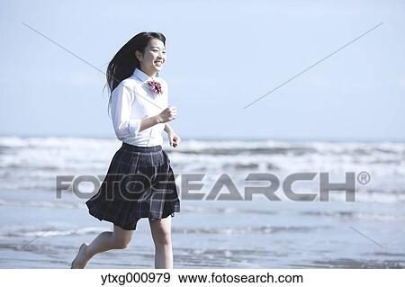 Young Japanese woman in a high school uniform running by the sea, Chiba, Japan View Large Photo Image Stock Photo - Young Japanese woman in a high school uniform running by the sea, Chiba, Japan. Fotosearch