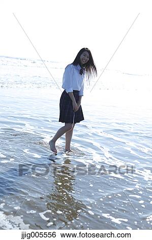 Stock Photograph - Young Japanese woman in a high school uniform by the sea, Chiba, Japan. Fotosearch