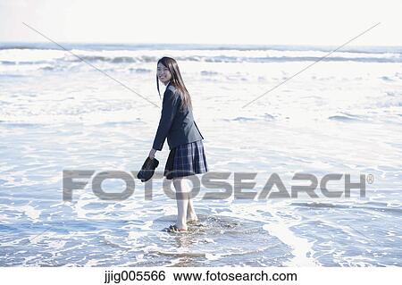 Stock Photograph - Young Japanese woman in a high school uniform by the sea, Chiba, Japan. Fotosearch