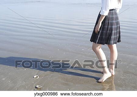 Stock Photograph - Young Japanese woman in a high school uniform by the sea, Chiba, Japan. Fotosearch