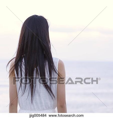 Young Japanese woman in a white dress at a cliff over the sea at sunrise, Chiba, Japan View Large Photo Image Picture - Young Japanese woman in a white dress at a cliff over the sea at sunrise, Chiba, Japan. Fotosearch