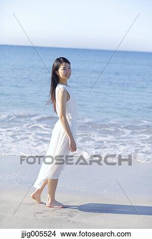 Picture - Young Japanese woman in a white dress by the sea, Chiba, Japan. Fotosearch