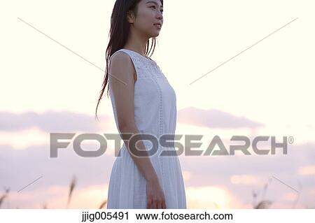 Young Japanese woman in a white dress at a cliff over the sea at sunrise, Chiba, Japan View Large Photo Image Stock Image - Young Japanese woman in a white dress at a cliff over the sea at sunrise, Chiba, Japan. Fotosearch