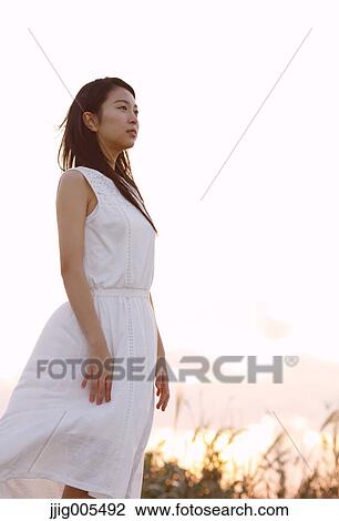 Young Japanese woman in a white dress at a cliff over the sea at sunrise, Chiba, Japan View Large Photo Image Stock Image - Young Japanese woman in a white dress at a cliff over the sea at sunrise, Chiba, Japan. Fotosearch
