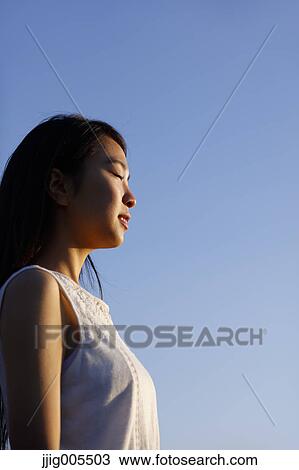 Young Japanese woman in a white dress at a cliff over the sea at sunrise, Chiba, Japan View Large Photo Image Stock Image - Young Japanese woman in a white dress at a cliff over the sea at sunrise, Chiba, Japan. Fotosearch