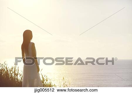 Young Japanese woman in a white dress at a cliff over the sea at sunrise, Chiba, Japan View Large Photo Image Stock Image - Young Japanese woman in a white dress at a cliff over the sea at sunrise, Chiba, Japan. Fotosearch