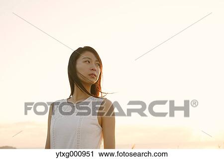 Young Japanese woman in a white dress at a cliff over the sea at sunrise, Chiba, Japan View Large Photo Image Stock Image - Young Japanese woman in a white dress at a cliff over the sea at sunrise, Chiba, Japan. Fotosearch