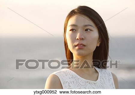 Young Japanese woman in a white dress at a cliff over the sea at sunrise, Chiba, Japan View Large Photo Image Stock Image - Young Japanese woman in a white dress at a cliff over the sea at sunrise, Chiba, Japan. Fotosearch