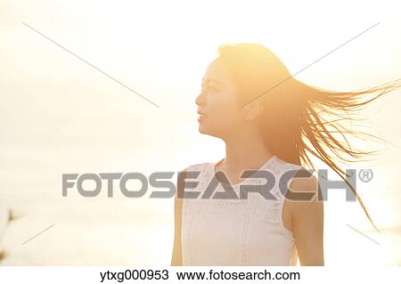 Young Japanese woman in a white dress at a cliff over the sea at sunrise, Chiba, Japan View Large Photo Image Stock Image - Young Japanese woman in a white dress at a cliff over the sea at sunrise, Chiba, Japan. Fotosearch