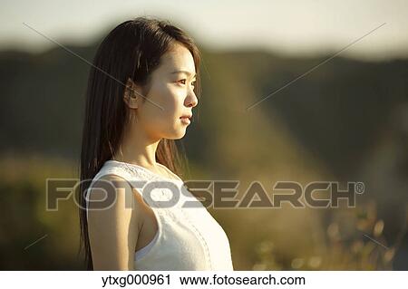 Young Japanese woman in a white dress at a cliff over the sea at sunrise, Chiba, Japan View Large Photo Image Stock Image - Young Japanese woman in a white dress at a cliff over the sea at sunrise, Chiba, Japan. Fotosearch