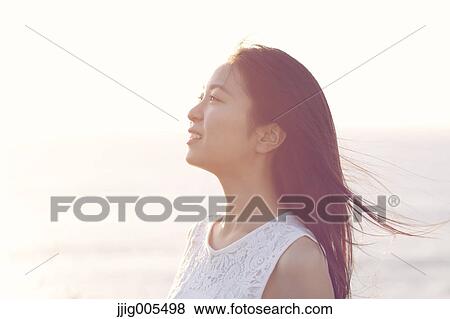 Young Japanese woman in a white dress at a cliff over the sea at sunrise, Chiba, Japan View Large Photo Image Stock Photo - Young Japanese woman in a white dress at a cliff over the sea at sunrise, Chiba, Japan. Fotosearch