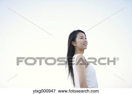 Young Japanese woman in a white dress at a cliff over the sea at sunrise, Chiba, Japan View Large Photo Image Stock Photo - Young Japanese woman in a white dress at a cliff over the sea at sunrise, Chiba, Japan. Fotosearch