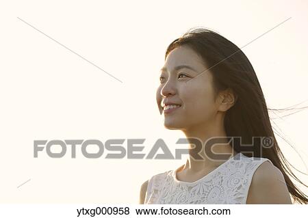 Young Japanese woman in a white dress at a cliff over the sea at sunrise, Chiba, Japan View Large Photo Image Stock Photo - Young Japanese woman in a white dress at a cliff over the sea at sunrise, Chiba, Japan. Fotosearch