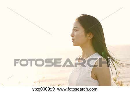 Young Japanese woman in a white dress at a cliff over the sea at sunrise, Chiba, Japan View Large Photo Image Stock Photo - Young Japanese woman in a white dress at a cliff over the sea at sunrise, Chiba, Japan. Fotosearch