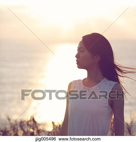 Young Japanese woman in a white dress at a cliff over the sea at sunrise, Chiba, Japan View Large Photo Image Stock Photograph - Young Japanese woman in a white dress at a cliff over the sea at sunrise, Chiba, Japan. Fotosearch