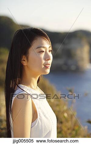 Young Japanese woman in a white dress at a cliff over the sea at sunrise, Chiba, Japan View Large Photo Image Stock Photography - Young Japanese woman in a white dress at a cliff over the sea at sunrise, Chiba, Japan. Fotosearch