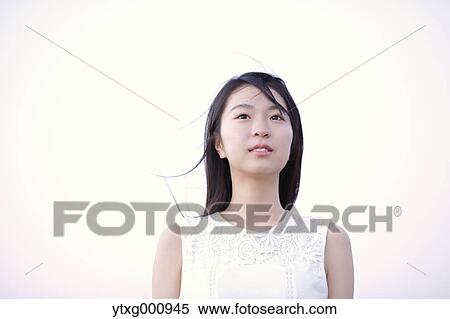 Young Japanese woman in a white dress at a cliff over the sea at sunrise, Chiba, Japan View Large Photo Image Stock Photography - Young Japanese woman in a white dress at a cliff over the sea at sunrise, Chiba, Japan. Fotosearch