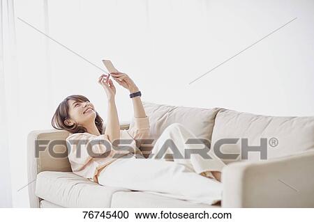 Young Japanese woman on sofa View Large Photo Image Stock Image - Young Japanese woman on sofa. Fotosearch