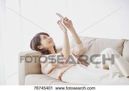 Young Japanese woman on sofa View Large Photo Image Stock Image - Young Japanese woman on sofa. Fotosearch
